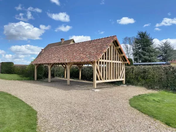 Charreterie colombage avec toiture en petites tuiles normandes, inspirée du modèle Bocage Lenoir Bois