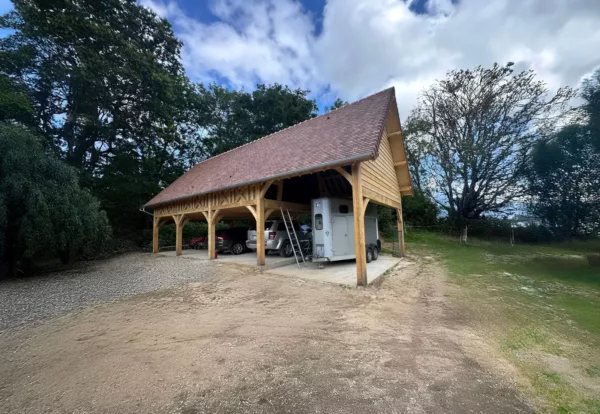 Espace de garage en bois à 4 travées avec l’option rabagrain, inspirée du modèle Bessin Lenoir Bois