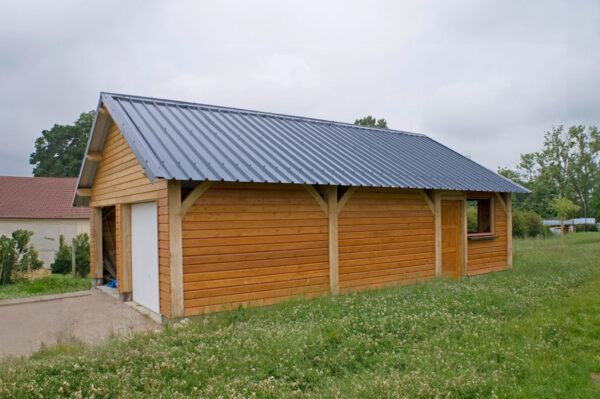 Garage en bois avec poteaux apparents à l'extérieur, inspiré du modèle Ouistreham Lenoir Bois